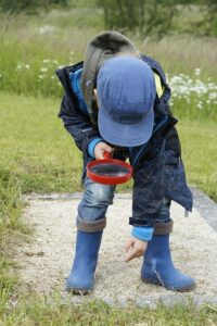 child using a magnifying glass 